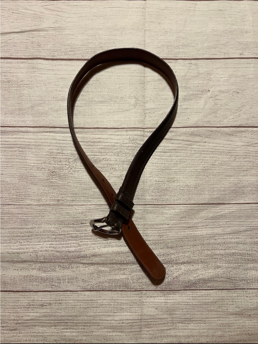 a vintage Coach brown leather belt featuring a classic horseshoe-style buckle